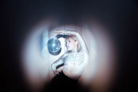 girl in a disco outfit with a disco ball