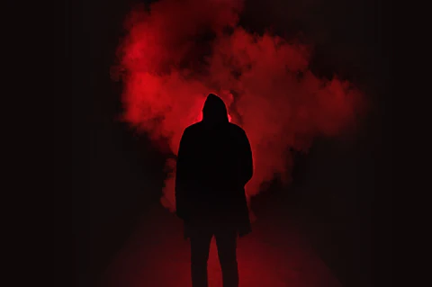 the man wears a hoodie in dark