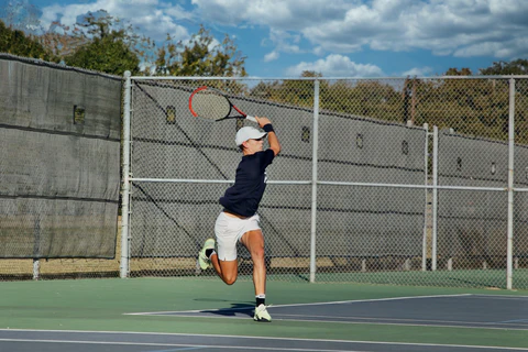 man plays tennis on a court 