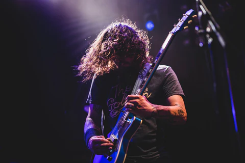 man plays a guitar and wearing a ring