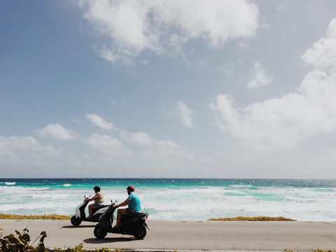 people riding a moped at beach