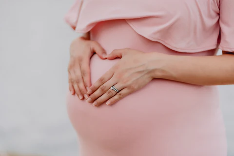 a pregnant woman in a pink dress