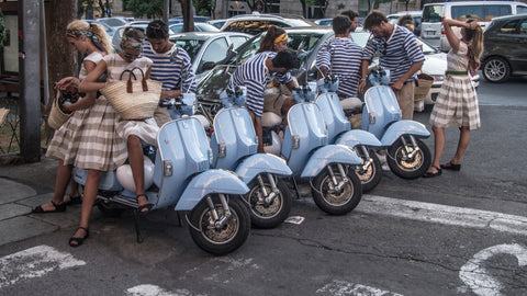 people and vespas in the street