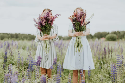 sisters with flowers in a field