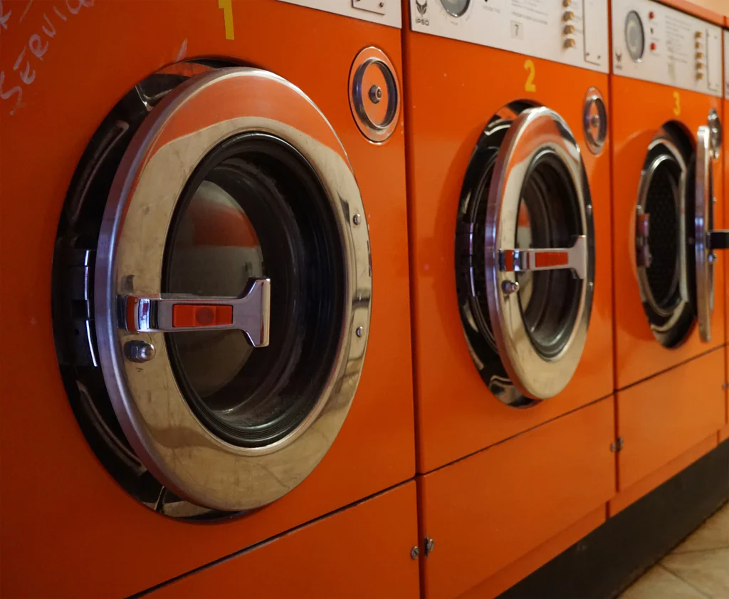 three orange washing machines