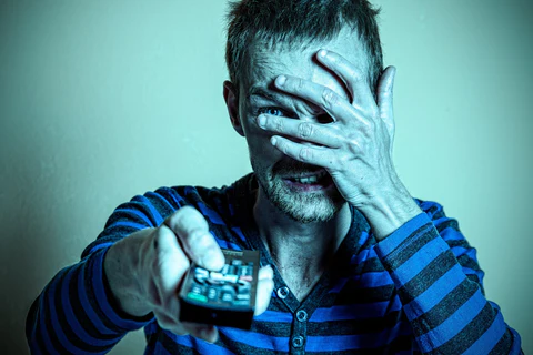 a man is watching a horror movie