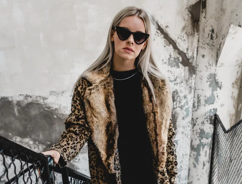 a blonde woman in a leopard printed coat